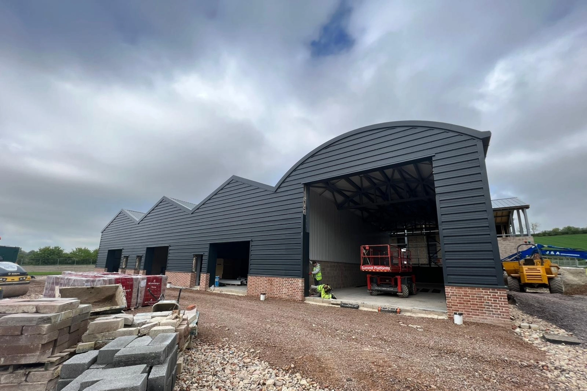 Technicians installing side cladding panels on an industrial façade
